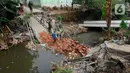 Truk terbalik dan terperosok di Kali Cabang Barat saat tengah mengangkut genting dan melintasi jembatan. (merdeka.com/ Arie Basuki)