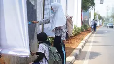 Pelajar mengecat  coretan yang mengotori tembok  saat kericuhan dalam unjuk rasa di Senayan, Jakarta, Jumat (4/10/2019). Para siswa dan alumni SMA menutup coret-coretan  itu sekaligus mengampanyekan cinta damai dalam praktik demokrasi di Indonesia. (Liputan6.com/Immanuel Antonius)