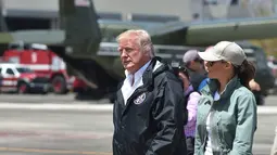 Presiden AS, Donald Trump dan Ibu Negara AS, Melania Trump setibanya di Luis Muñiz Air National Guard Base, Puerto Rico, Selasa (3/10). Dalam kunjungannya, Melania menggunakan sepatu boot kerja untuk digunakan meninjau daerah bencana. (HECTOR RETAMAL/AFP)