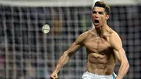 Striker Real Madrid Cristiano Ronaldo menunjukkan ototnya saat merayakan gol usai membobol gawang Juventus lewat tendangan penalti dalam petandingan Liga Champions di stadion Santiago Bernabeu, Madrid (11/4). (AFP Photo/Oscar Del Pozo)