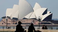 Pengunjung menghabiskan sore mereka di depan Sydney Opera House (21/8/2021). Kota itu memperpanjang penguncian selama dua bulan dan memberlakukan jam malam sebagian untuk menahan wabah virus corona yang menyebar cepat. (AFP/David Gray)