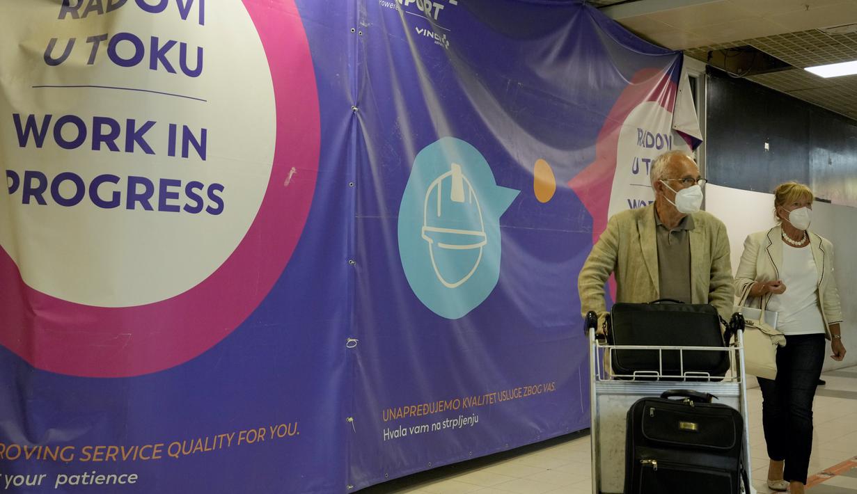 Penumpang melewati gedung bandara di Beograd, Serbia, Rabu (21/9/2022). Ketika pengumuman wajib milter oleh Presiden Rusia disiarkan di televisi, pencarian kata-kata 'tiket' dan 'pesawat' pun meningkat hingga dua kali lipat di Google. (AP Photo/Darko Vojinovic)