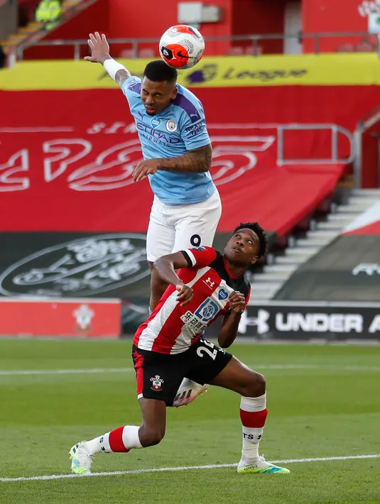 Penyerang Manchester City, Gabriel Jesus  melompati pemain Southampton Kyle Walker-Peters dalam lanjutan Liga Inggris di St. Mary Stadium, Minggu (5/7/2020).  Manchester City gagal memetik poin penuh setelah kalah tipis 0-1 saat bertandang ke markas Southamtpon. (AP Photo/Frank Augstein, Pool)