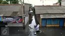 Warga melawati jalanan yang banjir di kawasan Jakarta Barat, Jumat (26/2). Banjir terjadi juga dikarenakan kali Daan Mogot yang  tak kunjung surut. (Liputan6.com/Faisal R Syam)