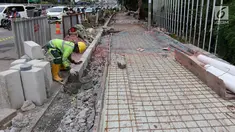 Pekerja menggarap proyek penataan jalur pedestrian di Jalan Gatot Subroto, Jakarta, Selasa (13/3). Penataan ini bertujuan untuk memberi kenyamanan dan keamanan bagi pejalan kaki. (Liputan6.com/Arya Manggala)