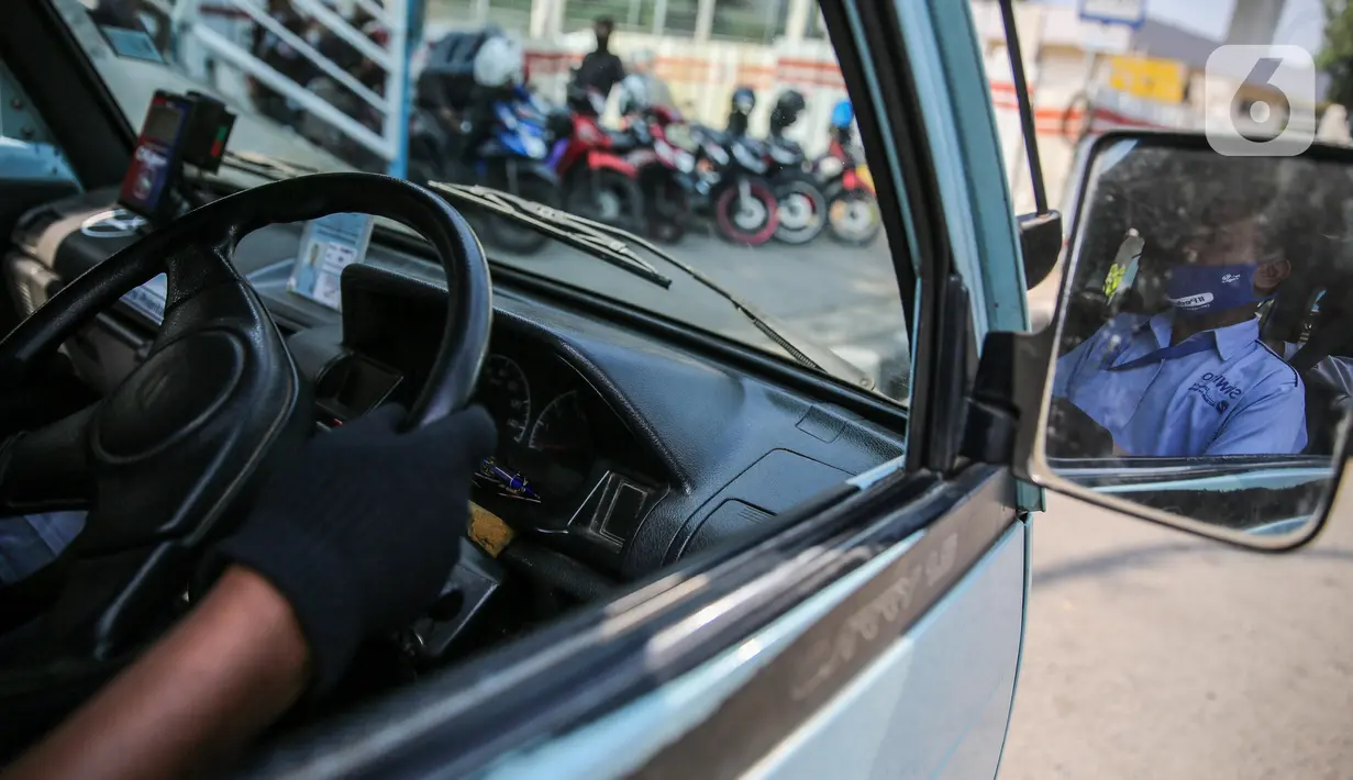Sopir angkutan umum Jak Lingko mengenakan masker dan sarung tangan di kawasan Cawang, Jakarta, Senin (6/7/2020). Pada perpanjangan masa PSBB transisi, angkutan umum sudah mulai beroperasi kembali dengan menerapkan protokol Kesehatan Covid-19. (Liputan6.com/Faizal Fanani)
