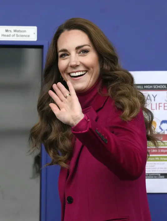 Kate Middleton, Duchess of Cambridge melambaikan tangan saat tiba untuk berkunjung ke Nower Hill High School di Harrow, London utara (24/11/2021). Ia mengikuti pelajaran sains yang mempelajari ilmu saraf dan pentingnya perkembangan anak usia dini bersama para siswa. (AFP/Pool/Kirsty Wigglesworth)