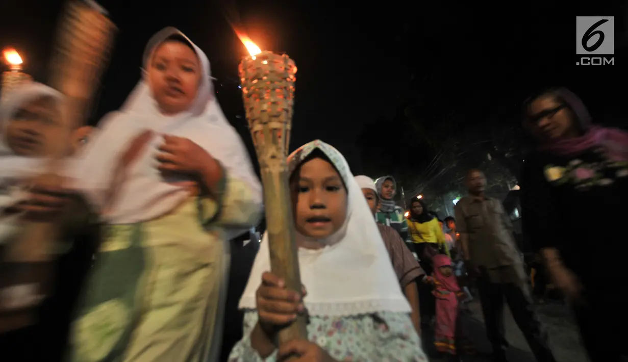 Seorang anak membawa obor saat pawai Tahun Baru Islam 1440 H di Menteng, Jakarta, Senin (10/9). Pawai obor yang diiringi musik bernuansa Islam merupakan tradisi umat muslim di Indonesia menyambut Tahun Baru 1 Muharram. (Merdeka.com/Iqbal S Nugroho)