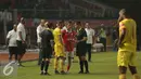 Wasit Djumadi E berbincang dengan kapten Persija dan Sriwijaya FC saat penghentian laga Torabika Soccer Championship presented by IM3 Ooredoo di Stadion GBK Jakarta, Jumat (24/6). Saatdihentikan, Sriwijaya FC unggul 1-0. (Liputan6.com/Helmi Fithriansyah)