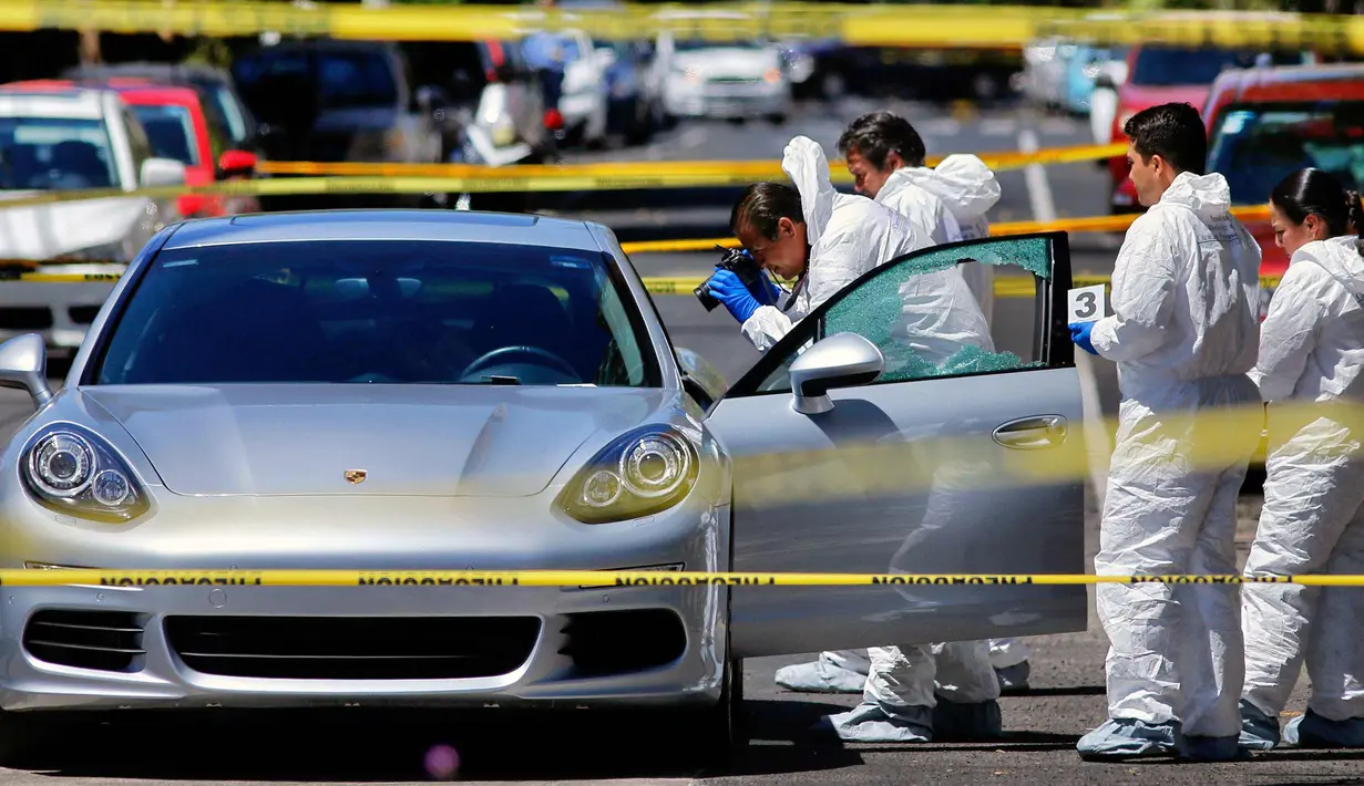 Tim forensik melakukan olah tempat kejadian perkara penembakan pengendara mobil sport Porsche oleh orang tidak dikenal di Guadalajara, Meksiko, (14/3). Pihak berwenang mencatat 25.339 pembunuhan pada tahun 2017. (AFP Photo/Ulises Ruiz)