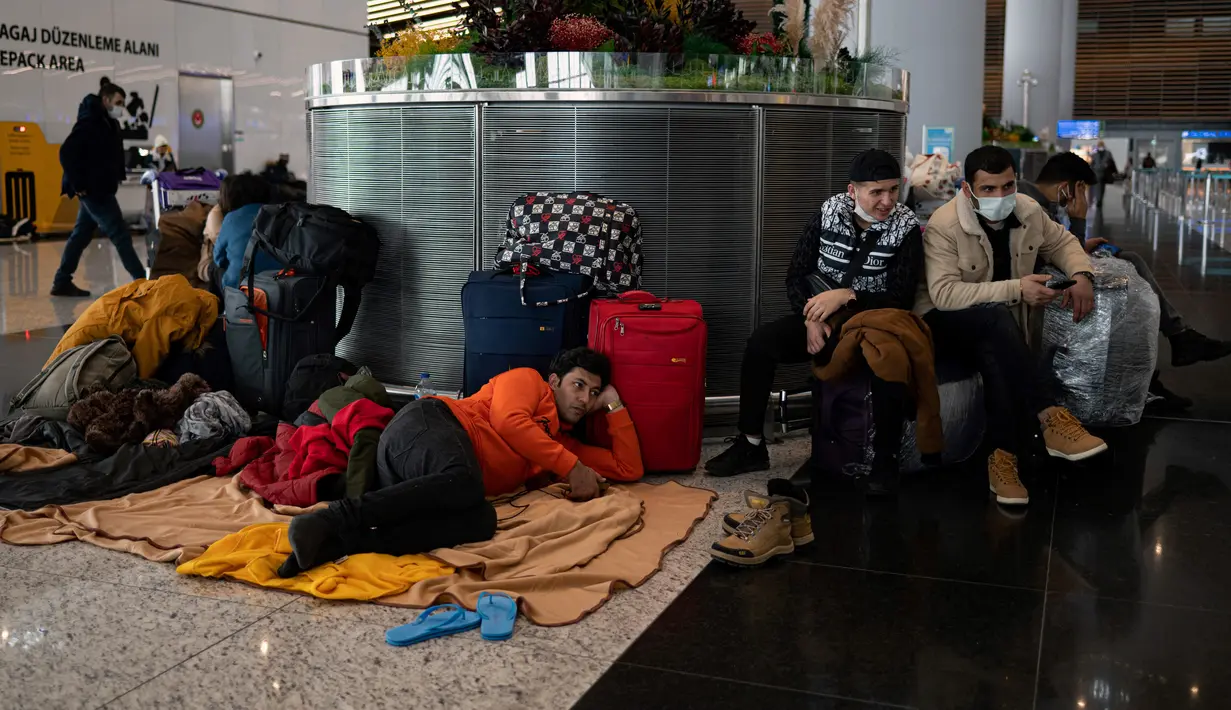 Penumpang yang terdampar menunggu di bandara Istanbul, di mana penerbangan dibatalkan karena badai salju dan hujan salju lebat, di Istanbul, Turki, pada 25 Januari 2022. Bandara Istanbul menunda pengoperasian kembali karena kondisi cuaca buruk yang menghambat operasional. (Yasin AKGUL/AFP)