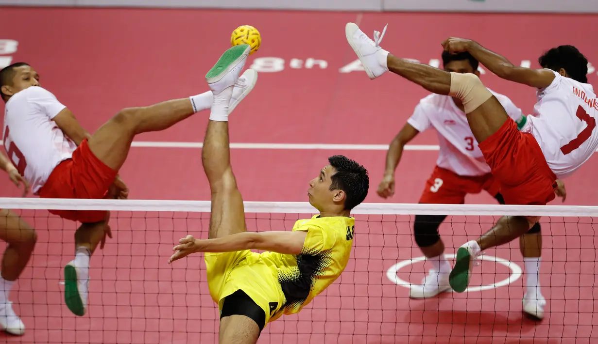 Pemain takraw Jepang, Toshitaka Naito (pusat) mendapat halauan Nofrizal Nofrizal dan Saiful Rijal saat akan menendang bola di final Asian Games 2018 di Palembang, Sabtu (1/9). Indonesia menang 2-1 atas Jepang. (AP Photo/Vincent Thian)