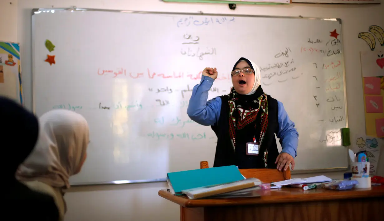 Hiba Al-Sharfa mengajar muridnya yang menderita Down Syndrome di sekolah Asosiasi Hak Hidup di Kota Gaza (21/12). Hiba mengajar di Right to Live, sebuah LSM di Jalur Gaza yang peduli terhadap anak-anak dengan Down Syndrome. (Reuters/Suhaib Salem)