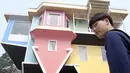 Pengunjung berjalan masuk menuju rumah terbalik di Huashan Creative Park, Taipei, Taiwan, Selasa (8/3/2016). Rumah yang dibangun selama dua minggu dengan biaya USD 600 ribu atau 8 miliar itu menarik banyak wisatawan. (SAM YEH/AFP)