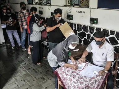 Petugas mendata warga yang hendak mengambil Bantuan Sosial Tunai (BST) di SMPN 3, Jakarta, Selasa (26/1/2021). Pencairan BST di Provinsi DKI Jakarta dilakukan secara bertahap mulai Januari-April 2021. (merdeka.com/Iqbal S. Nugroho)