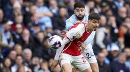 Gelandang Arsenal, Kai Havertz (depan) berebut bola dengan bek Manchester City, Josko Gvardiol pada laga pekan ke-30 Premier League 2023/2024 di Etihad Stadium, Manchester, Minggu (31/3/2024). (AP Photo/Dave Thompson)
