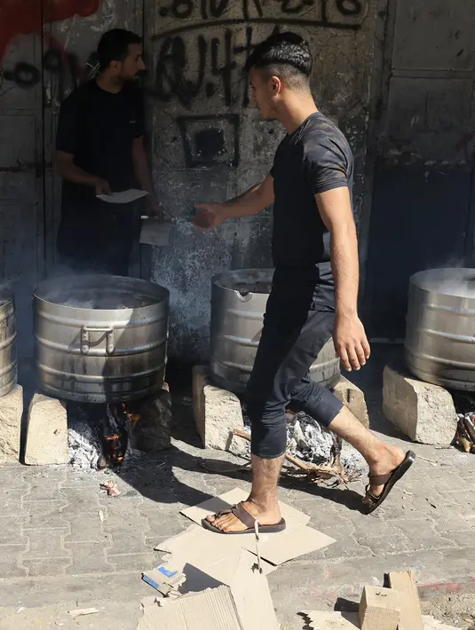 Makanan tersebut diperuntukan bagi warga Palestina yang kehilangan rumahnya karena hancur terkena serangan udara Israel. (MAHMUD HAMS / AFP)