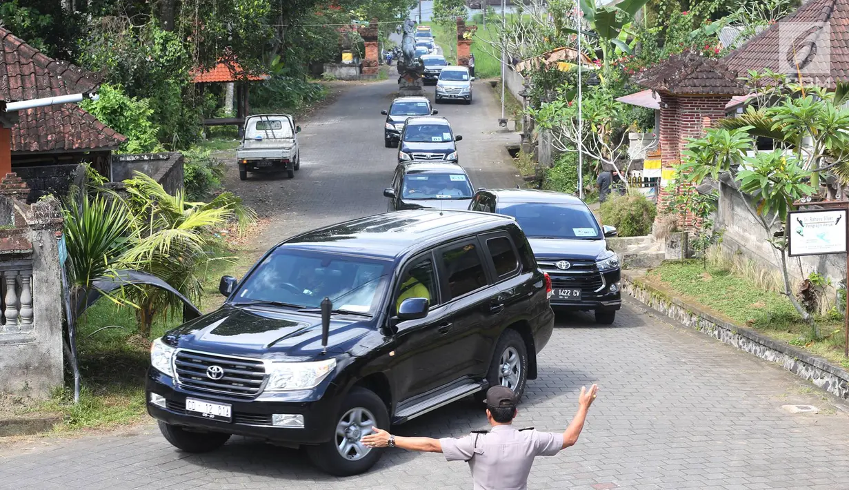 Seorang polisi mengatur lalu lintas iring-iringan mobil rombongan mantan Presiden Amerika Serikat Barack Obama melintas di kawasan Bongkasa, Badung, Bali, Senin (26/6). (Liputan6.com/Immanuel Antonius)