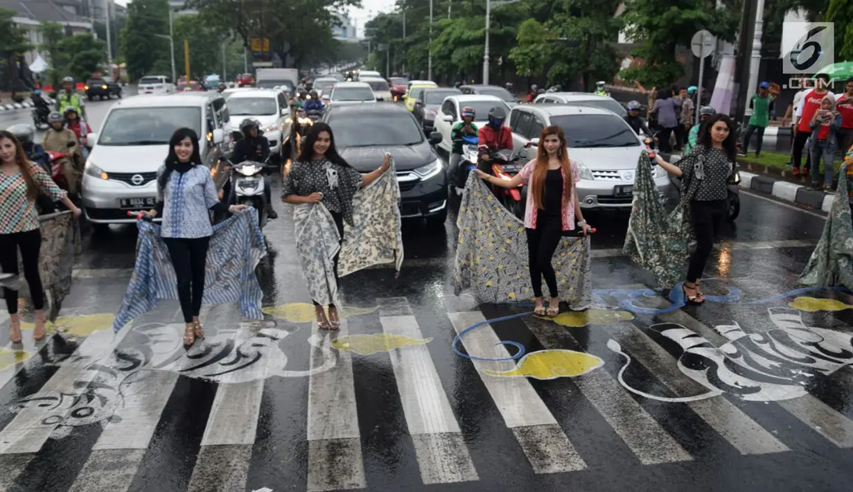 Aksi para model dari Bayu Ramli Modeling saat membagikan takjil di perempatan Jalan Pahlawan, Semarang, Jawa Tengah, Jumat, (18/5). Acara ini merupakan bagian dari kegiatan amal para model. (Liputan6.com/Gholib)