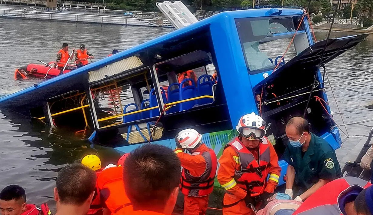 Tim penyelamat berusaha mengevakuasi sebuah bus yang jatuh ke danau di Anshun, provinsi Guizhou, China, Selasa (7/7/2020). Sedikitnya 21 orang tewas usai bus yang  membawa siswa untuk mengikuti ujian masuk perguruan tinggi atau gaokao itu menabrak pagar pembatas lalu tercebur ke danau. (STR/AFP)