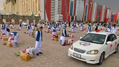 Pengantin pria berdiri bersama dengan hadiah di luar aula pernikahan selama upacara pernikahan massal di Kabul, Afghanistan, 13 Juni 2022. Puluhan wanita Afghanistan yang disembunyikan dalam selendang hijau tebal dinikahkan dalam pernikahan massal yang ketat di Kabul. (Sahel ARMAN/AFP)