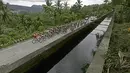 Pebalap melintasi jembatan air Indarung buatan Belanda pada Etape 6 Tour de Singkarak 2016 yang menempuh jarak 151,1 km dari Padang Pariaman menuju Sawahlunto, Kamis (11/8/2016). (Bola.com/Nicklas Hanoatubun)