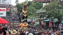 Ribuan orang berkerumun mengikuti prosesi ngaben Anak Agung Niang Agung di Bali, Indonesia, Jumat (2/3). Ngaben ini disebut melibatkan sekitar 4.500 warga dari 12 desa adat di kawasan Ubud dan disaksikan ribuan wisatawan. (AP Photo/Firdia Lisnawati)
