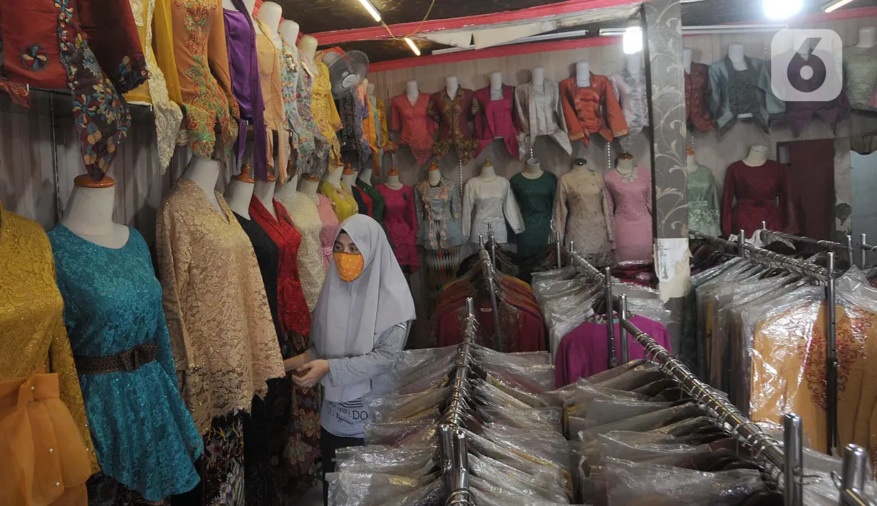 Seorang wanita melihat busana di toko di sentra konveksi Bulak Timur, Depok, senin (11/5/2020). Jelang Lebaran 2020, pembuat dan penjual konveksi di kawasan ini mengeluhkan anjloknya penjualan hingga 80% hingga 90% akibat dampak pandemi Covid-19. (merdeka.com/Arie Basuki)