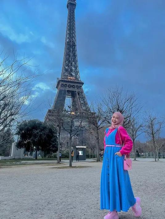 Overal long dress nuansa pink-biru yang dipadukan pashmina baby pink dapat membuat OOTD-mu terlihat lebih manis. (Instagram/riaricis1795).