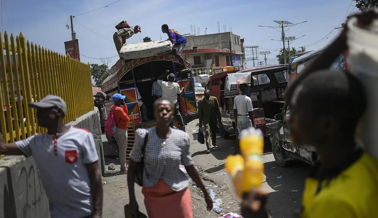 Penduduk setempat memuat kasur di atap bus di pasar Petion-Ville di Port-au-Prince, empat hari setelah pembunuhan Presiden Haiti Jovenel Moise, Minggu (11/7/2021). Moïse tewas dibunuh dalam serangan di kediaman pribadinya, pada Rabu 7 Juli 2021 dini hari. (AP Photo/Matias Delacroix)