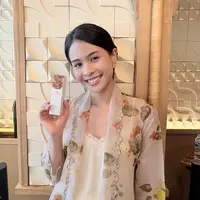 Maudy Ayunda memegang serum terbaru dari From This Island  berbahan dasar kunyit. [Anisha/Fimela]