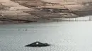 Reruntuhan bekas desa Aceredo yang biasanya terendam, muncul dari pembangkit listrik tenaga air waduk Lindoso karena permukaan air yang rendah, di dekat Lobios, barat laut Spanyol, pada 22 November 2021. Puing-puing bangunan rumah dan bangkai kendaraan tua muncul ke permukaan. (MIGUEL RIOPA/AFP)