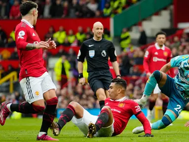 Pemain Manchester United Casemiro (tengah bawah) beraksi melawan pemain Southampton Carlos Alcaraz (kanan) pada pertandingan sepak bola Liga Inggris di Stadion Old Trafford, Manchester, Inggris, 12 Maret 2023. Pertandingan berakhir imbang dengan skor 0-0. (AP Photo/Jon Super)