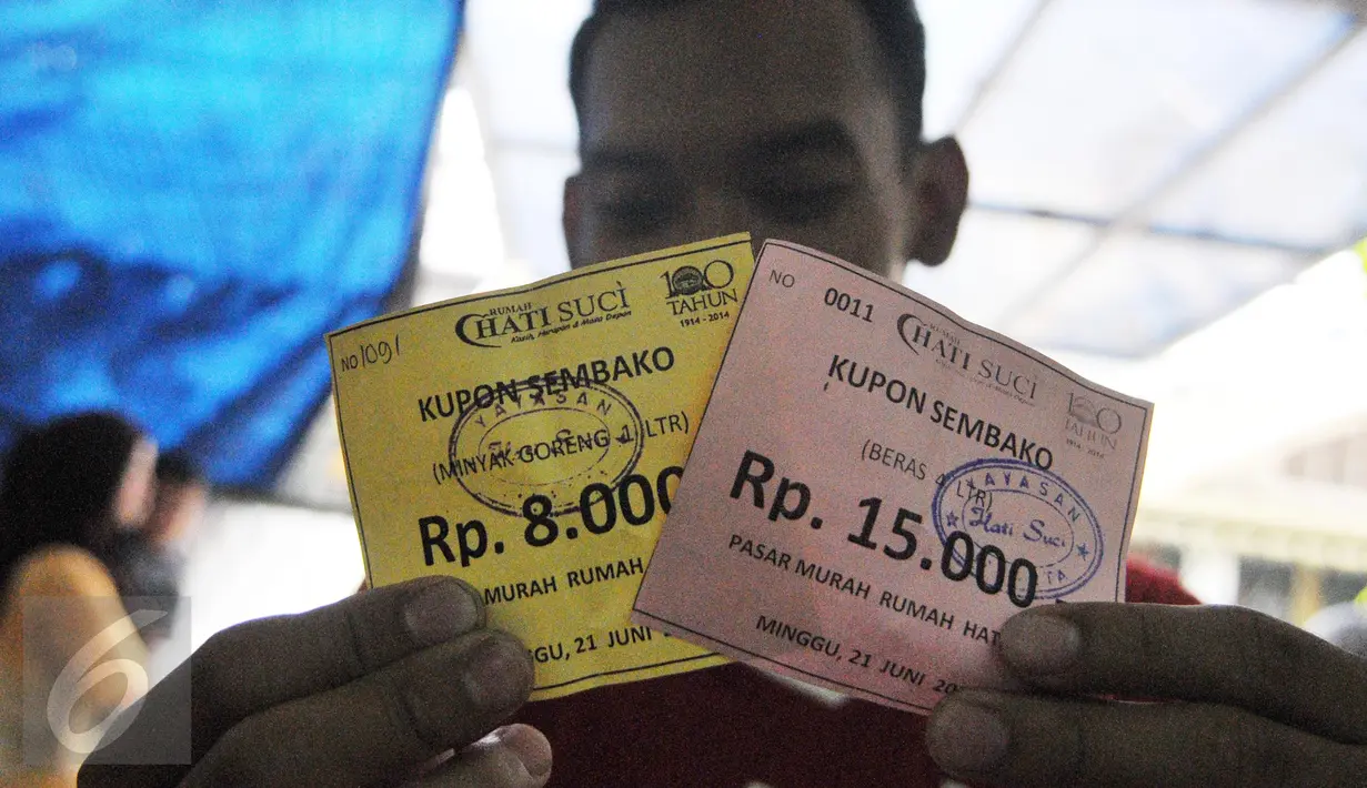 Seorang warga memperlihatkan kupon sembako di Rumah Hati Suci, Jakarta, Minggu (21/6/2015). Warga terlihat  antusias membeli barang di pasar murah tersebut. (Liputan6.com/Herman Zakharia)