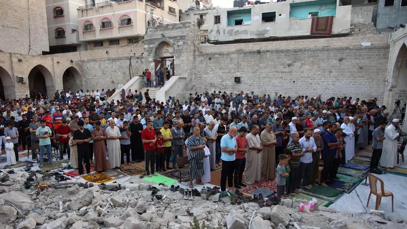 Warga Palestina melaksanakan salat Idul Adha di halaman Masjid Omari yang bersejarah di Kota Gaza, yang rusak akibat pemboman Israel. (Omar Al-Qattaa/AFP)