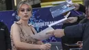 Aimee Lou Wood memberikan tanda tangan kepada penggemar saat menghadiri pemutaran perdana film 'Living' selama Festival Film London 2022 di London, Minggu, 9 Oktober 2022. Aimee memilih palet riasan perunggu yang menonjolkan fitur alaminya dengan sapuan lipstik nude. (Photo by Vianney Le Caer/Invision/AP)
