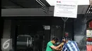 Pekerja menancapkan plang segel ruko Nazaruddin yang berada di Wijaya Grand Center, Jakarta Selatan, Senin (28/11). Ruko tersebut masuk dalam daftar kekayaan Nazaruddin yang dirampas negara. (Liputan6.com/Helmi Affandi)
