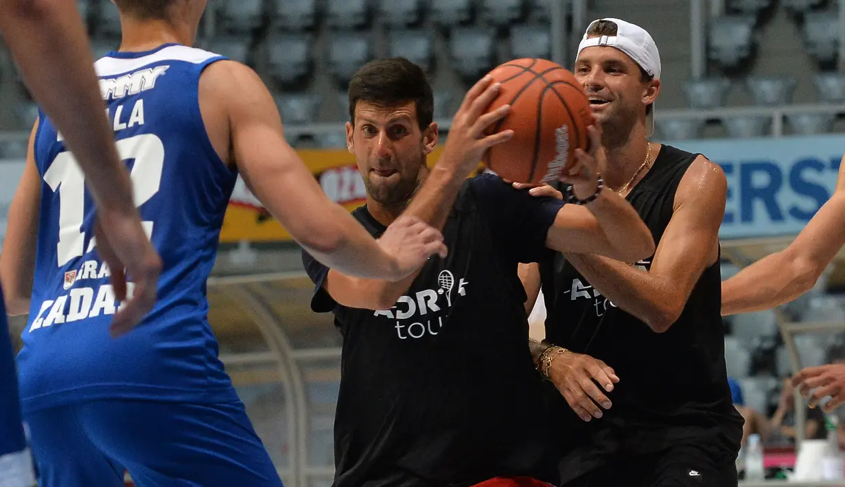 Petenis Serbia, Novak Djokovic bermain basket dengan pemain tenis Bulgaria Grigor Dimitrov, kanan, di Zadar, Kroasia (18/6/2020). Novak Djokovic dinyatakan positif mengidap virus corona setelah mengikuti serangkaian pameran tenis yang ia selenggarakan di Serbia dan Kroasia. (AP Photo/Zvonko Kucelin)