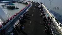 Banyak warga memanfaatkan momen liburan untuk menikmati senja di anjungan Jembatan Suroboyo, Kota Surabaya, Jawa Timur. (Liputan6.com/Dhimas Prasaja)