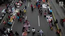Pedagang Kaki Lima (PKL) berjualan selama kegiatan Car Free Day (CFD) di sepanjang Jalan Sudirman, Jakarta, Minggu (9/12). Kurangnya pengawasan menyebabkan banyak PKL yang berjualan tidak pada tempatnya dan memenuhi area CFD. (Liputan6.com/Faizal Fanani)