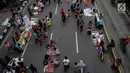 Pedagang Kaki Lima (PKL) berjualan selama kegiatan Car Free Day (CFD) di sepanjang Jalan Sudirman, Jakarta, Minggu (9/12). Kurangnya pengawasan menyebabkan banyak PKL yang berjualan tidak pada tempatnya dan memenuhi area CFD. (Liputan6.com/Faizal Fanani)