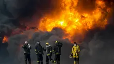 Petugas pemadam kebakaran saat berusaha memadamkan api di salah satu tangki minyak yang terbakar di pelabuhan Es Sider, Libya, (6.1).  Diduga penyebab kebakaran adalah serangan yang dilakukan oleh kelompok militan. (REUTERS / Stringer)