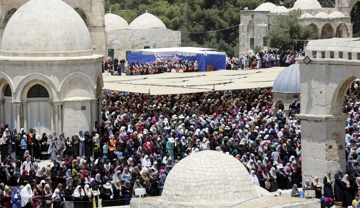 Jemaah muslim wanita Palestina melaksakan salat di depan Dome of the Rock atau Kubah Shakhrah yang berada di tengah kompleks Masjid Al Aqsa, Yerusalem (8/6). (AP/Mahmoud Illean)
