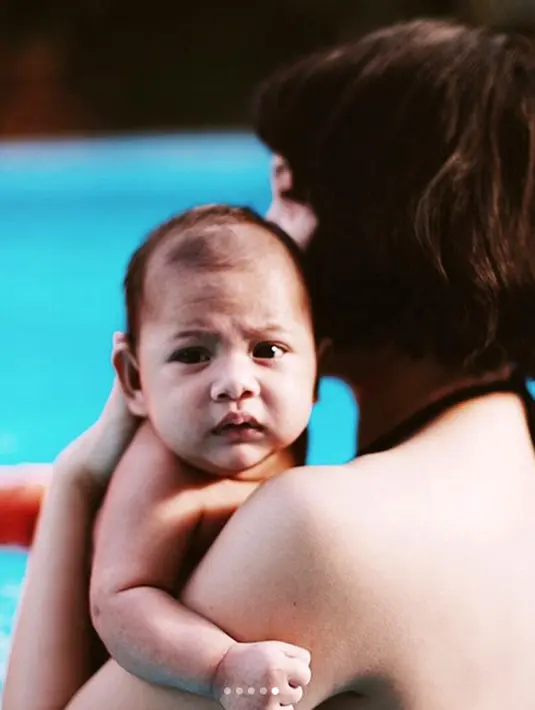 Andien mulai mengenalkan buah hatinya Kawa air dan kolam renang. Bayi berusia dua bulan itu terlihat renang dengan dipandu oleh seorang pelatih. (Instagram/andienippekawa)