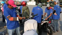Petugas mengemas sepeda motor untuk diangkut dengan kereta api Stasiun Kampung Bandan, Jakarta, Senin (11/6). Program mudik gratis ini digagas Kemenhub tersebut melayani pengiriman ke beberapa daerah di Pulau Jawa. (Liputan6.com/Immanuel Antonius)