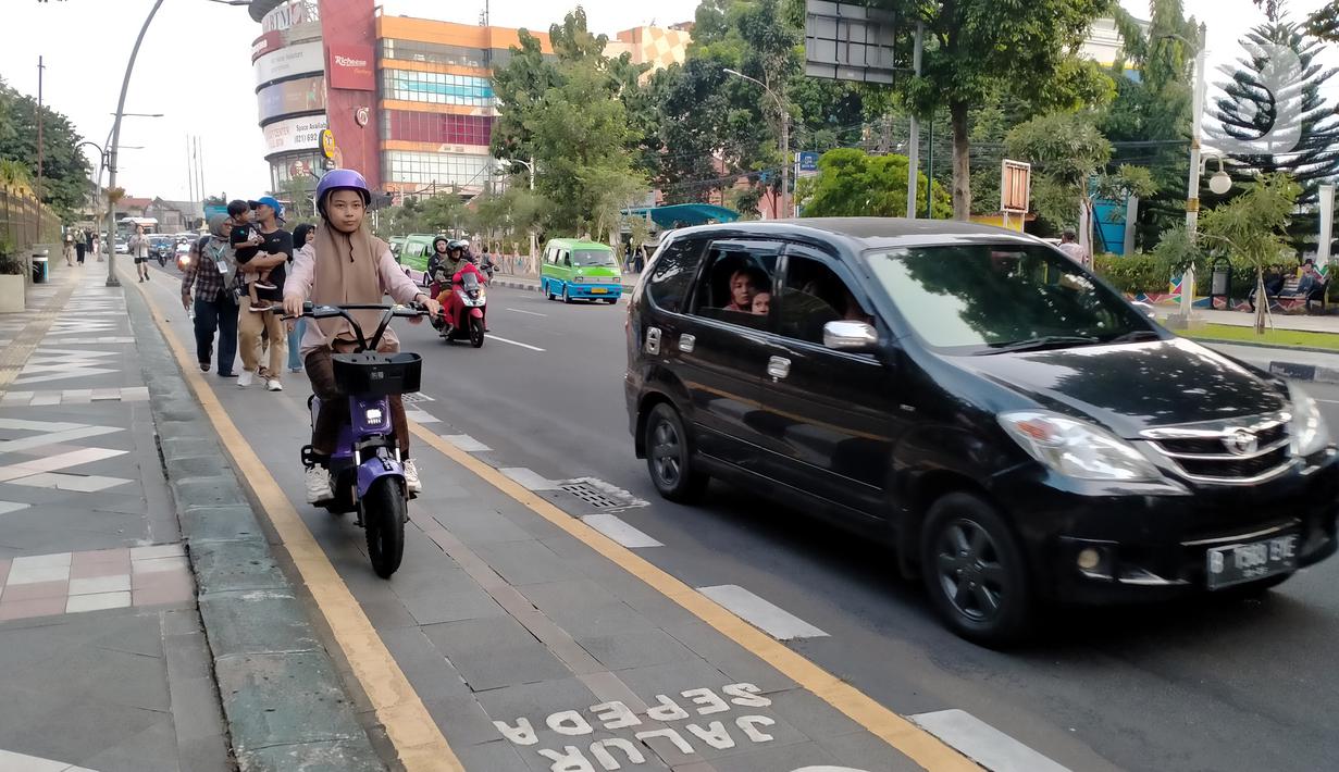 Warga mengendarai sepeda listrik saat berkeliling di jalur sepeda kawasan Kebun Raya Bogor, Kota Bogor, Jawa Barat, Minggu (25/9/2022). Pemerintah Kota (Pemkot) Bogor akan mulai membiasakan warganya untuk menggunakan transportasi dengan tenaga listrik. (Liputan6.com/Magang/Aida Nuralifa)