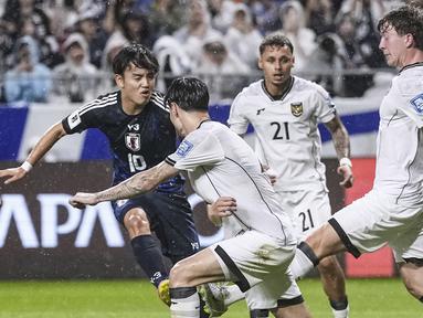 Pemain Jepang, Takefusa Kubo (kiri) berusaha mencetak gol ke gawang Timnas Indonesia dalam laga Grup C Putaran Ketiga Kualifikasi Piala Dunia 2026 di Suita Stadium, Jepang, Selasa (10/06/2025). (AP Photo/Kyodo News/Shohei Miyano)