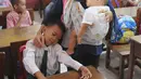 Seorang ibu menenangkan anaknya yang menangis saat hari pertama masuk sekolah di SDN Cinere 1, Depok, Jawa Barat, Senin (15/7/2019). Seluruh siswa SD, SMP dan SMA, pada hari ini mulai masuk sekolah pada tahun ajaran baru 2019/2020. (merdeka.com/Arie Basuki)