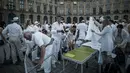 Peserta menyiapkan perlengkapan acara 'Diner en blanc' atau 'Makan Malam Putih' yang digelar di Place Vendome, Paris, Rabu (8/6). Ribuan orang mengenakan pakaian putih membawa meja, kursi dan keranjang penuh dengan makanan. (PHILIPPE LOPE/AFP)