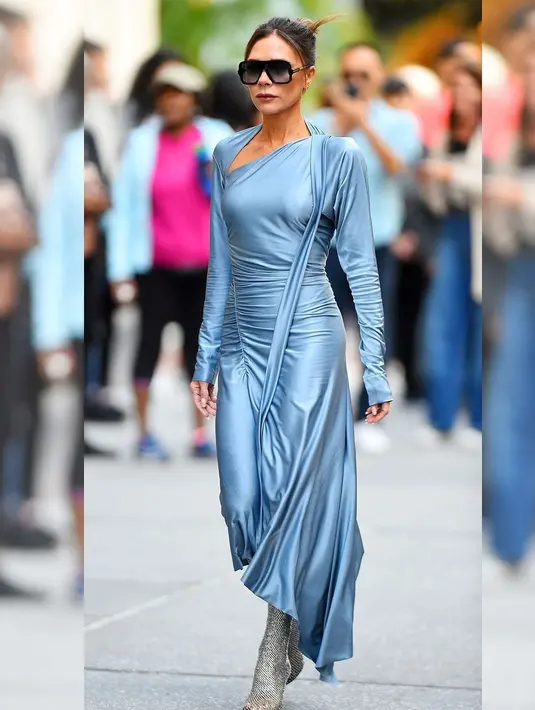 <p>Victoria Beckham tertangkap kamera dalam balutan gaun biru muda. Tampilannya yang ini sangat retro dengan gaun yang menutupi dada dan detail syal dramatis di sisinya. Untuk menyempurnakan penampilannya, ia memilih mengenakan sepasang sepatu boot stiletto mesh yang ketat dan berkilau. Foto: Instagram.</p>